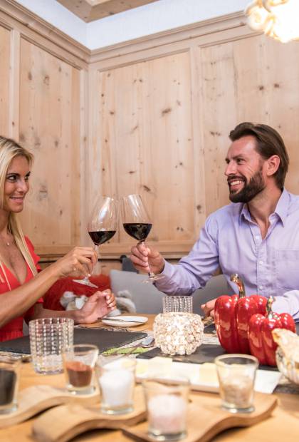 Paar beim Abendessen stößt mit Rotwein an