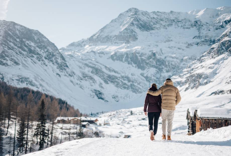 Paar spaziert im Schnee in den Südtiroler Alpen